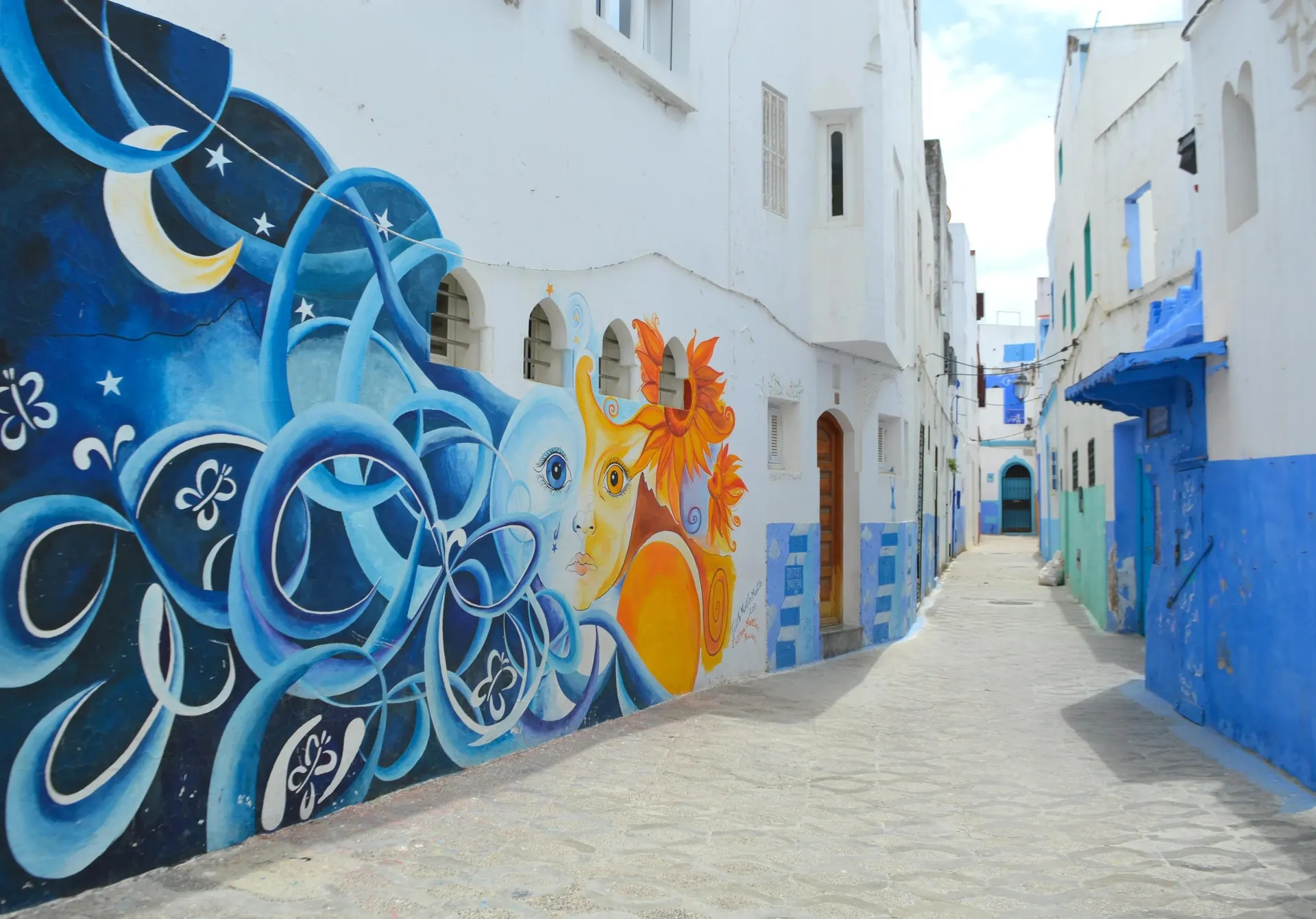A mural on a whitewashed lane of Asilah’s Medina