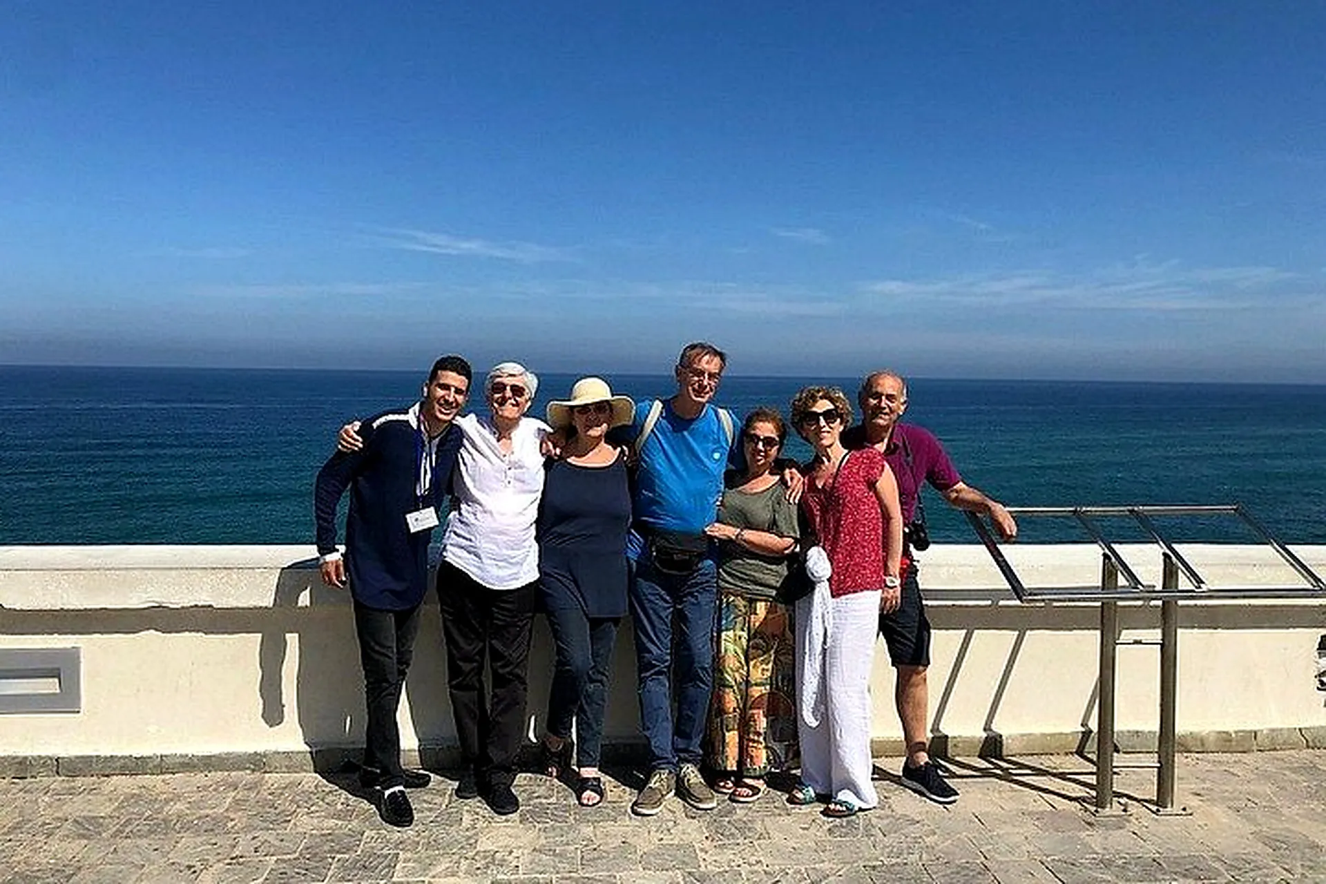 Guests with their guide on a terrace overlooking the sea